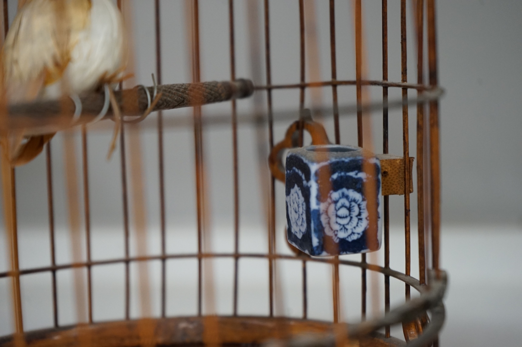 A pair of Chinese bamboo and metal birdcages with blue and white feeders. 34cm high not including hook